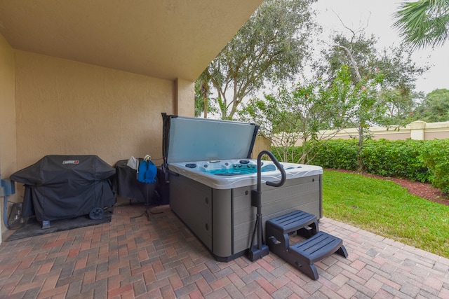 view of patio with a grill and a hot tub