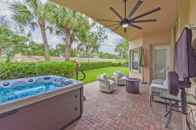 view of patio / terrace with ceiling fan and a hot tub