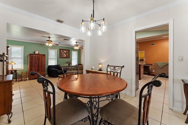 tiled dining area with a textured ceiling, ceiling fan, and crown molding