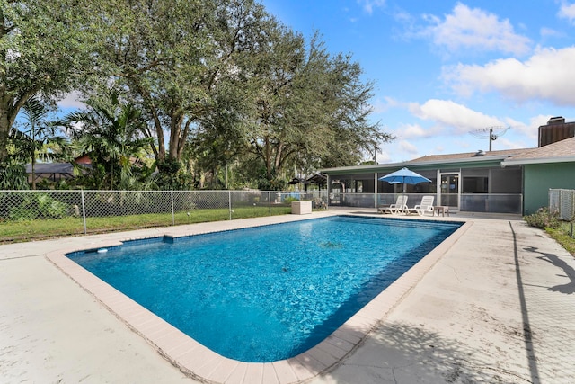 view of swimming pool with a patio area and a sunroom