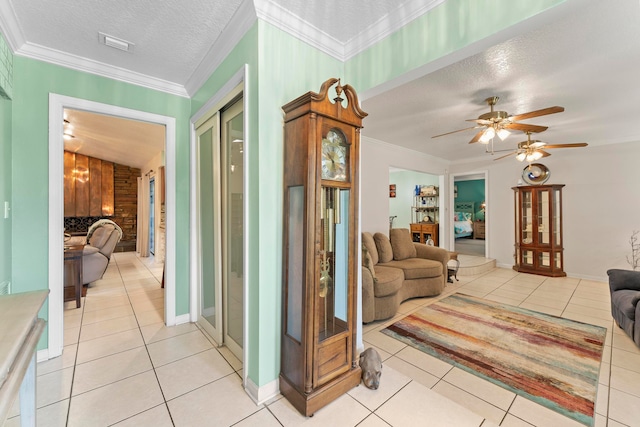 living room featuring crown molding, light tile patterned floors, and a textured ceiling