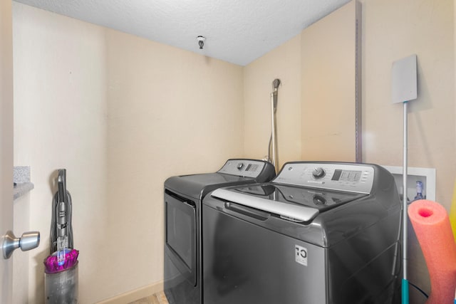 3009 S Ocean Blvd Unit 901, Highland Beach, FL 33487 - clothes washing area featuring independent washer and dryer, a textured ceiling, and baseboards