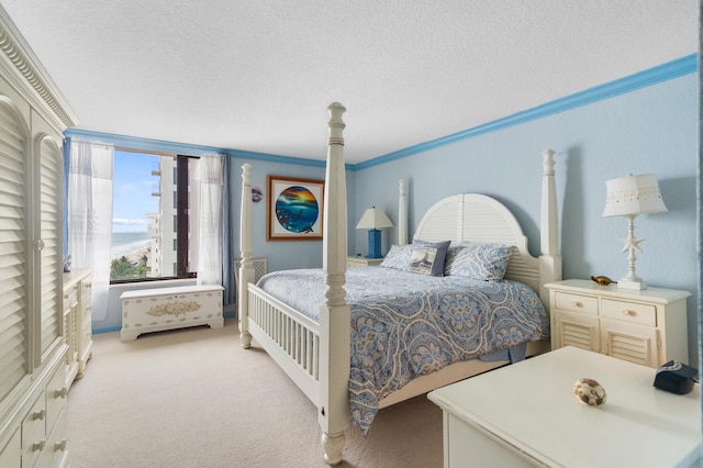 bedroom with a textured ceiling, light colored carpet, and crown molding