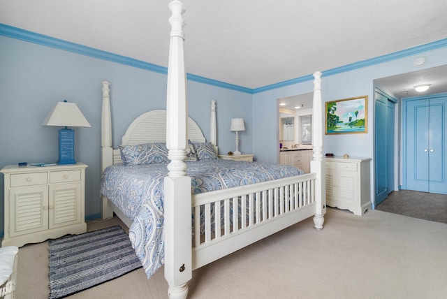 bedroom featuring light carpet, connected bathroom, and crown molding