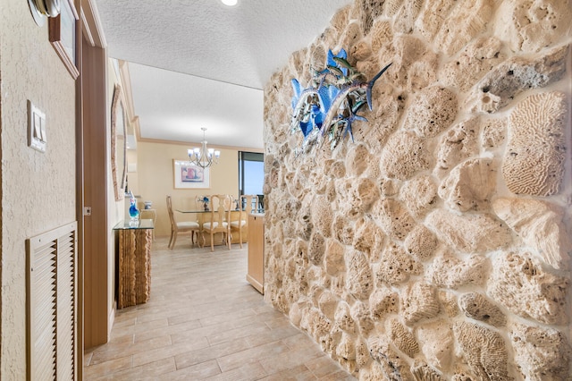 3009 S Ocean Blvd Unit 901, Highland Beach, FL 33487 - corridor with a chandelier, a textured ceiling, crown molding, and light wood-style flooring