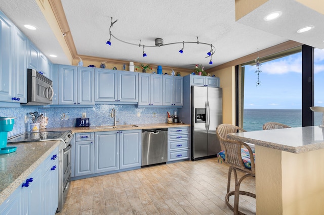 3009 S Ocean Blvd Unit 901, Highland Beach, FL 33487 - kitchen featuring stainless steel appliances, a sink, a breakfast bar area, decorative backsplash, and light wood finished floors