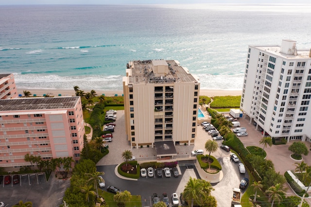 birds eye view of property featuring a water view and a beach view