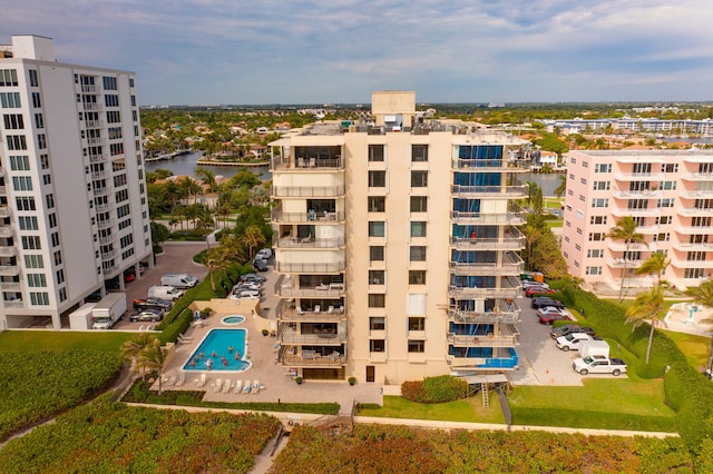 view of building exterior with a community pool and a water view