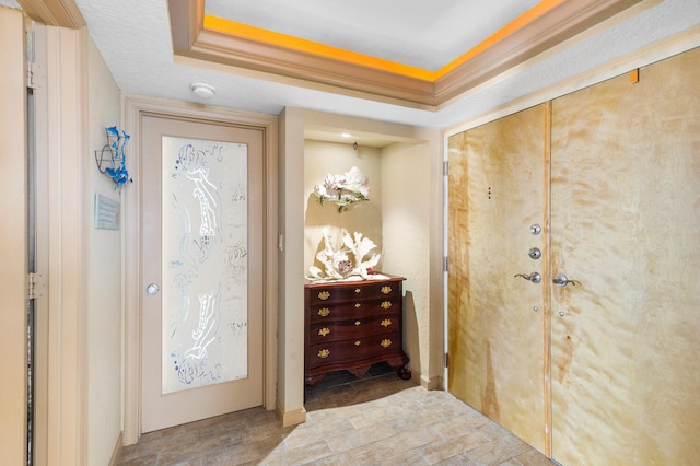 entrance foyer with light wood-type flooring and a tray ceiling