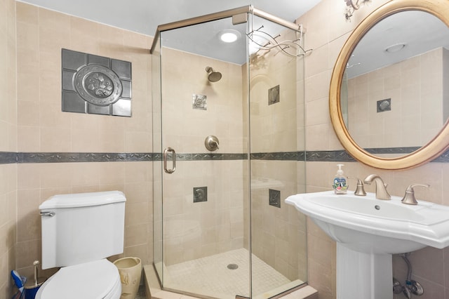 3009 S Ocean Blvd Unit 901, Highland Beach, FL 33487 - bathroom featuring tile walls, a stall shower, toilet, and a sink