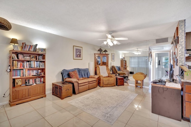 tiled living room featuring ceiling fan and a textured ceiling