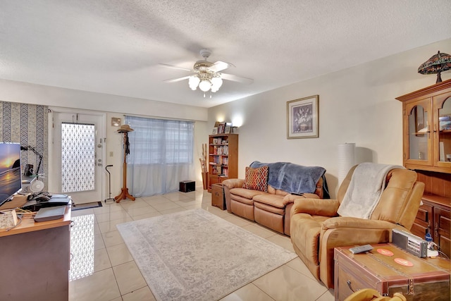 tiled living room with a textured ceiling and ceiling fan