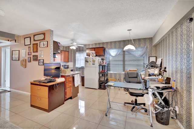 office area featuring ceiling fan, light tile patterned flooring, and a textured ceiling