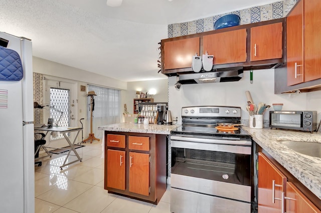 kitchen featuring light stone countertops, stainless steel electric stove, exhaust hood, light tile patterned floors, and white fridge