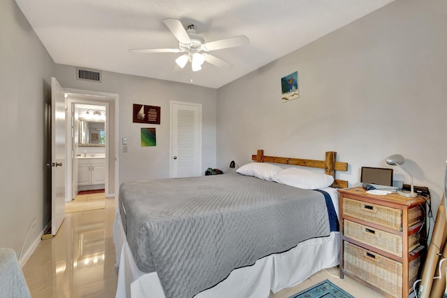 bedroom featuring connected bathroom, ceiling fan, a closet, and light tile patterned floors