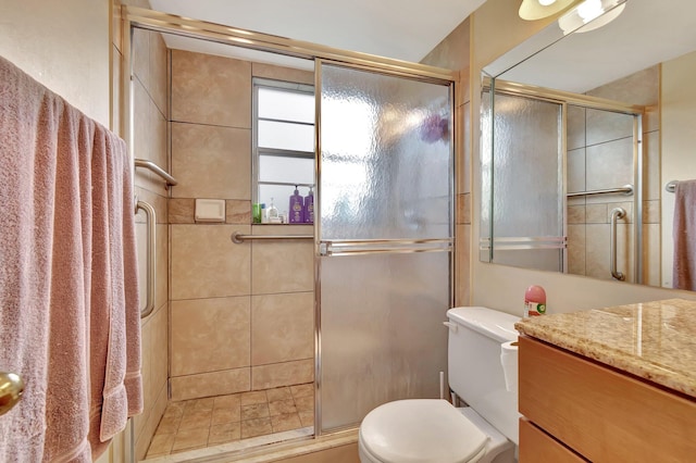 bathroom featuring vanity, toilet, and an enclosed shower