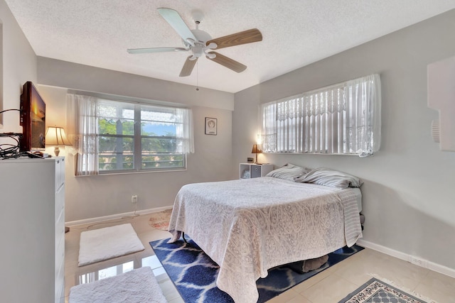 tiled bedroom featuring ceiling fan and a textured ceiling