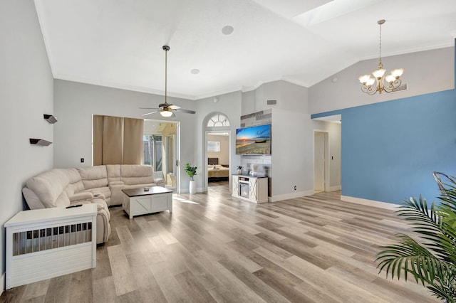 living room with ceiling fan with notable chandelier, light wood-type flooring, ornamental molding, and high vaulted ceiling