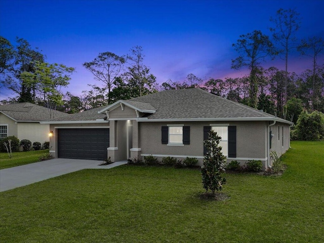 ranch-style home with a garage and a yard