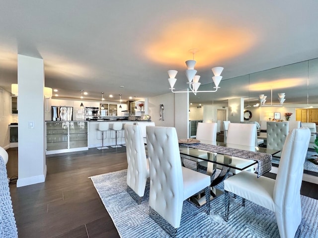 dining space featuring dark wood-type flooring and a chandelier