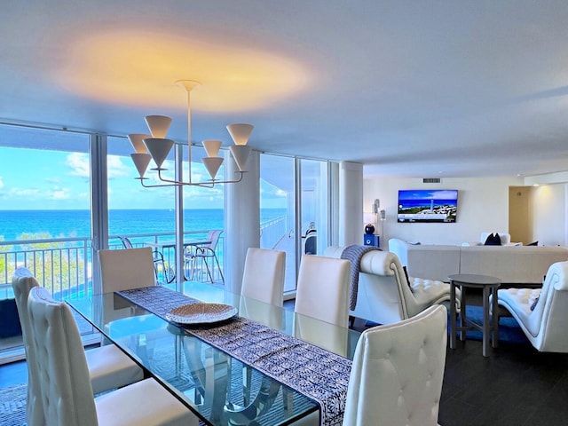 dining space with a chandelier, a water view, and hardwood / wood-style flooring