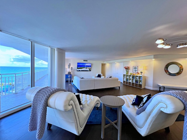 living room with dark hardwood / wood-style flooring and a water view