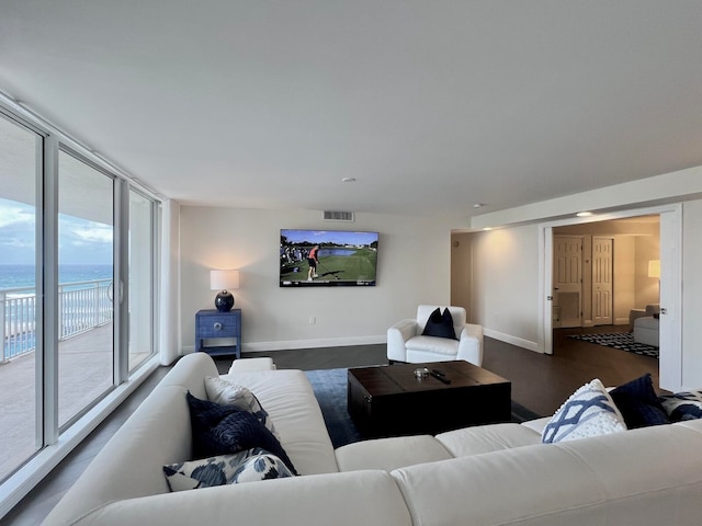 living room featuring a water view and dark wood-type flooring