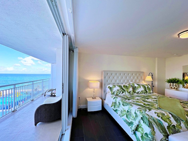 bedroom with a water view and hardwood / wood-style flooring