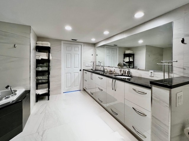 kitchen featuring white cabinetry, tile walls, and sink