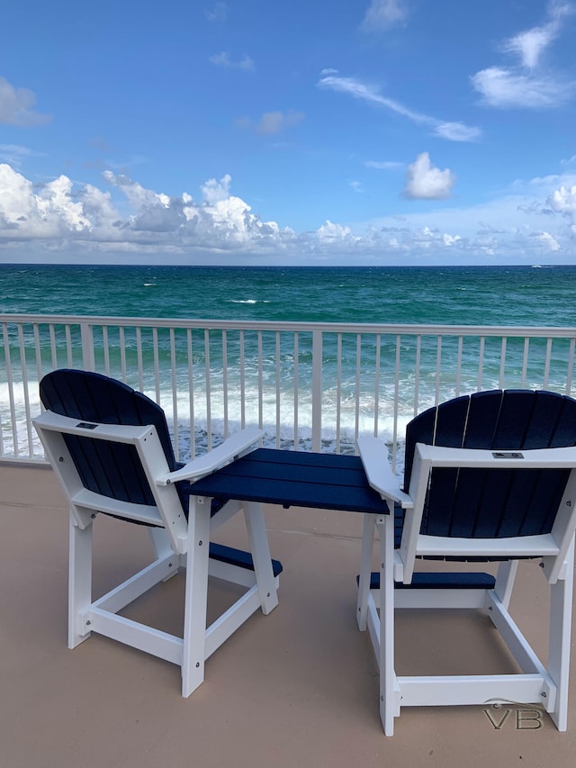 balcony with a water view and a beach view