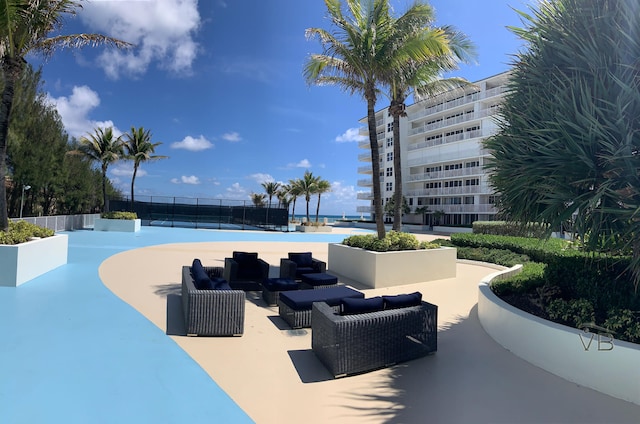 view of swimming pool featuring tennis court and an outdoor living space