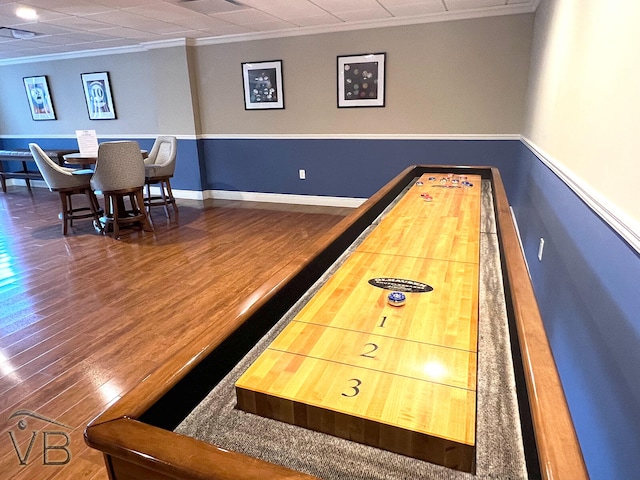 recreation room featuring dark wood-type flooring and ornamental molding