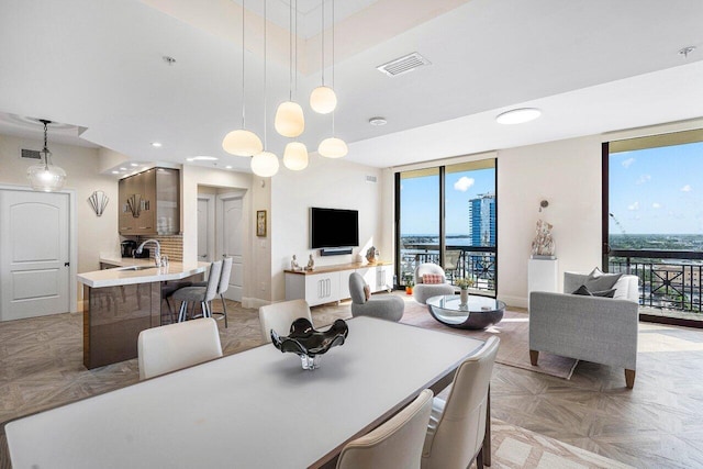 dining space featuring light parquet flooring, a healthy amount of sunlight, and sink