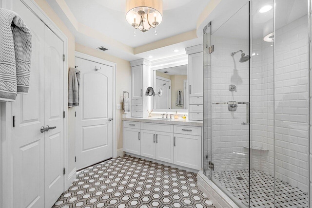 bathroom featuring vanity, a chandelier, and walk in shower