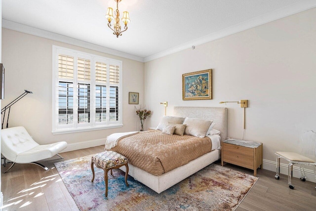 bedroom with ornamental molding, hardwood / wood-style flooring, and a notable chandelier