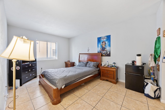 tiled bedroom featuring black refrigerator