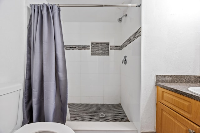 bathroom with walk in shower, vanity, and toilet