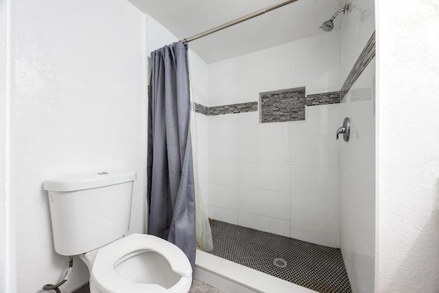 bathroom with curtained shower and toilet