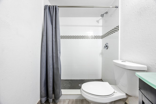 bathroom with toilet, a shower with curtain, vanity, and hardwood / wood-style floors