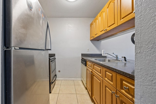 kitchen featuring a textured ceiling, appliances with stainless steel finishes, sink, and light tile patterned flooring