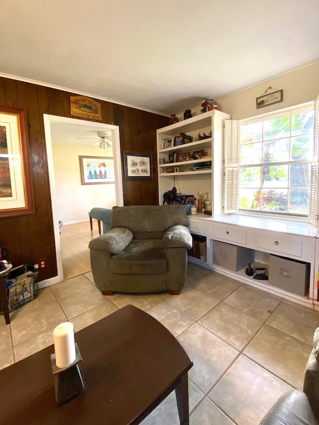 tiled living room featuring ceiling fan and wooden walls