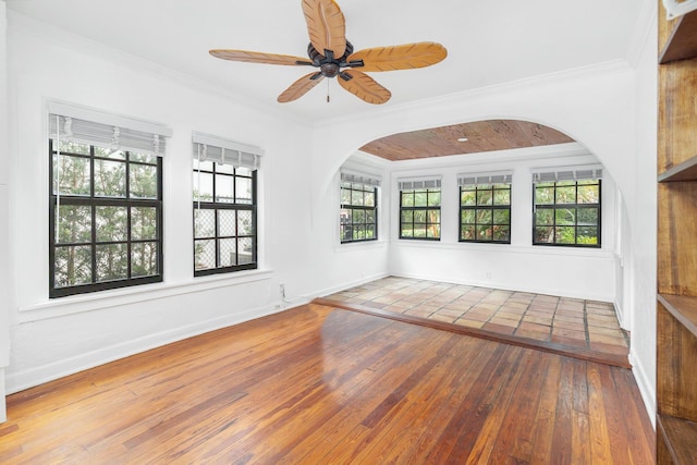 empty room with ceiling fan, ornamental molding, and wood-type flooring