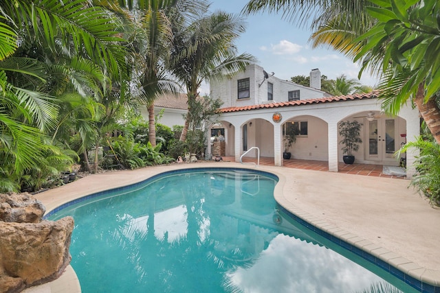 view of swimming pool with french doors and a patio area