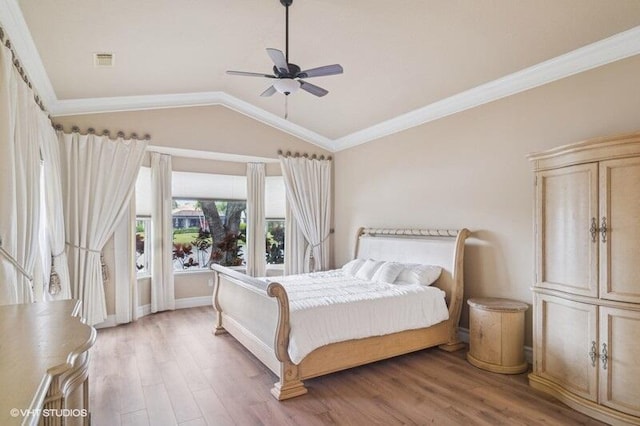 bedroom featuring light wood finished floors, visible vents, ornamental molding, vaulted ceiling, and a ceiling fan