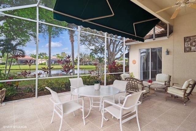 sunroom featuring a water view and ceiling fan