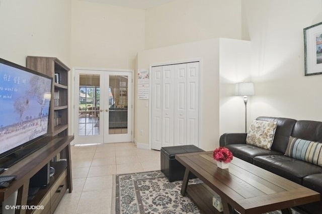 living room with a high ceiling, light tile patterned floors, and french doors