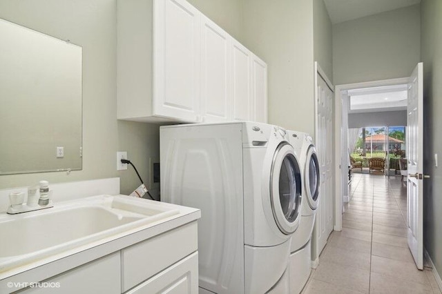 washroom featuring cabinets, washer and clothes dryer, sink, and light tile patterned floors