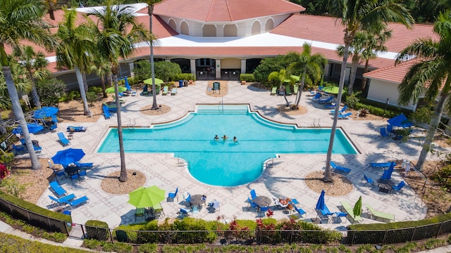 community pool with a patio and fence