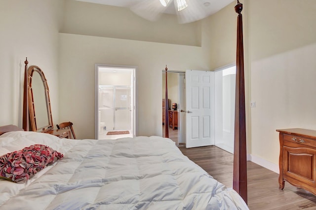 bedroom featuring hardwood / wood-style floors, ensuite bathroom, ceiling fan, and lofted ceiling