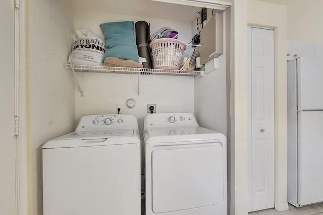 laundry room with washer and clothes dryer and light tile patterned floors